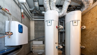 Boiler für Warm- und Kaltwasser in einem Mehrfamilienhaus (GEAK A/A) in Vollèges (VS), das ohne Zentralheizung auskommt. Das Warmwasser wird durch Solarenergie geheizt.