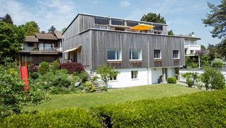 La maison individuelle située dans le canton de Fribourg a subi un assainissement énergétique conforme à Minergie-P et a été surélevée d'un étage (Villars-sur-Glâne, FR).